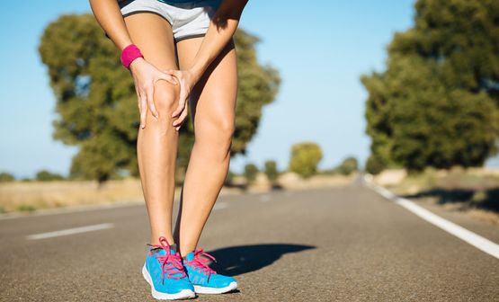 Sportlerin hält sich das Knie