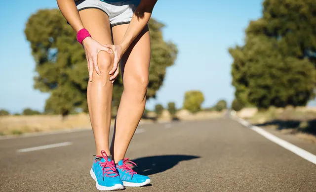 Sportlerin hält sich das Knie